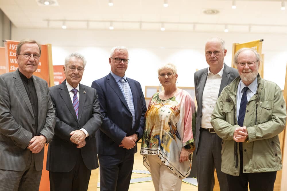 Gruppenbild mit Ulrich Schöler, Heinz Fischer, Karl Dworschak, Gabriele Plank, Stefan Paul-Jacobs und Wolfgang Thierse bei der Eröffnung der Wanderausstellung in Wien. Im Hintergrund ist die Wanderausstellung zu sehen.