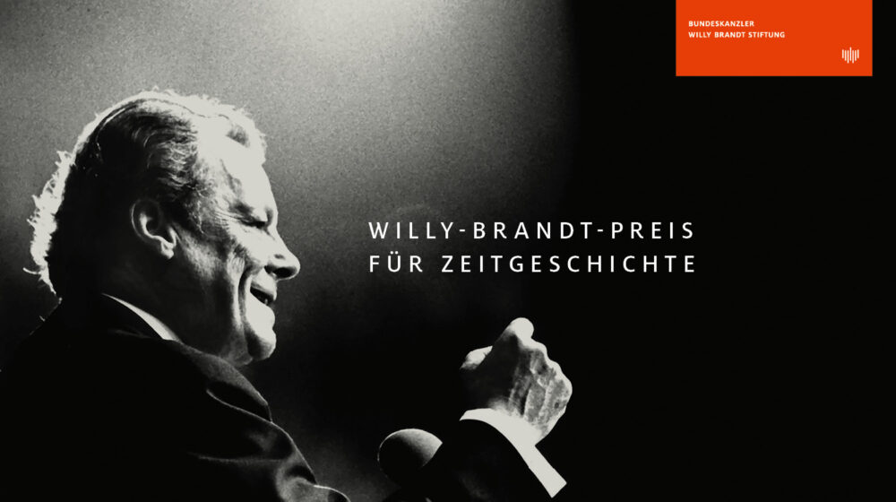 Willy Brandt hält eine Rede mit erhobener Faust. Zusätzlich steht Willy-Brandt-Preis für Zeitgeschichte auf dem Bild